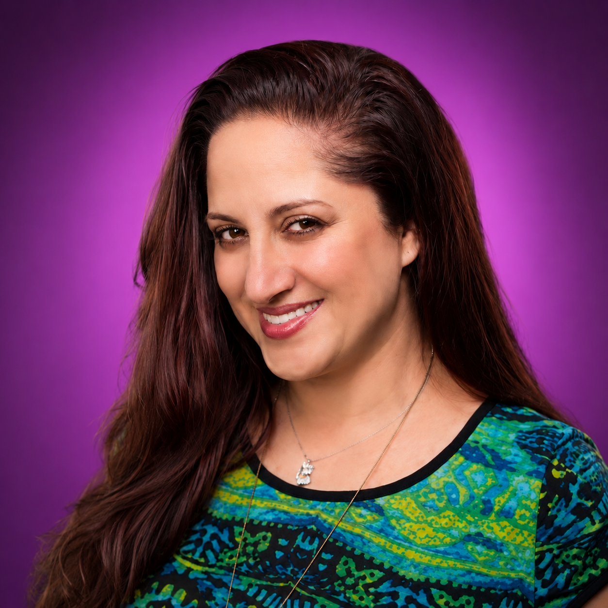 Dr. Adena Shaviva Blickstein, smiling in front of a vivid purple backdrop